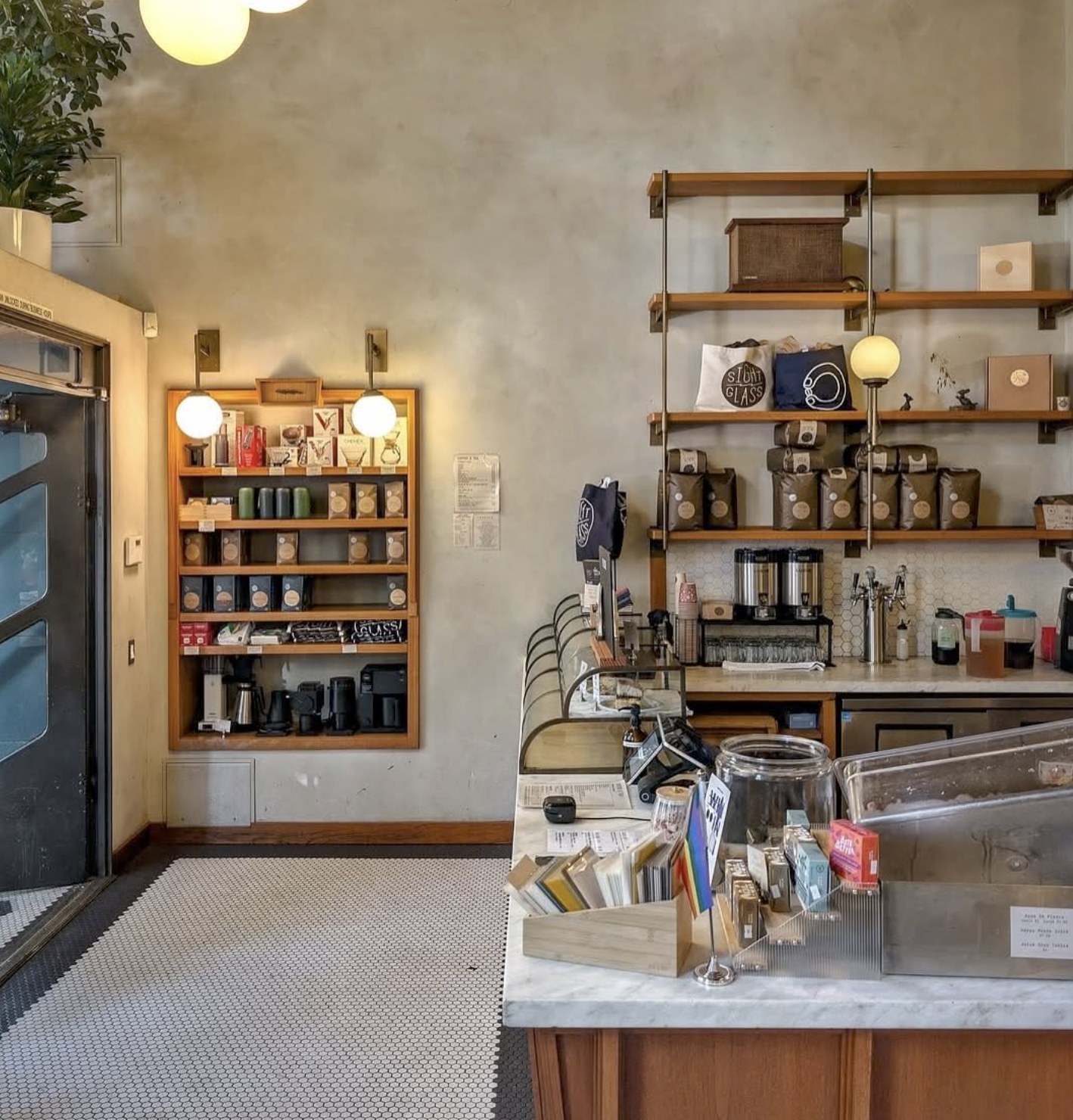 The retail wall of brewing gear and coffee bags beside the marble counter at Sightglass Coffee